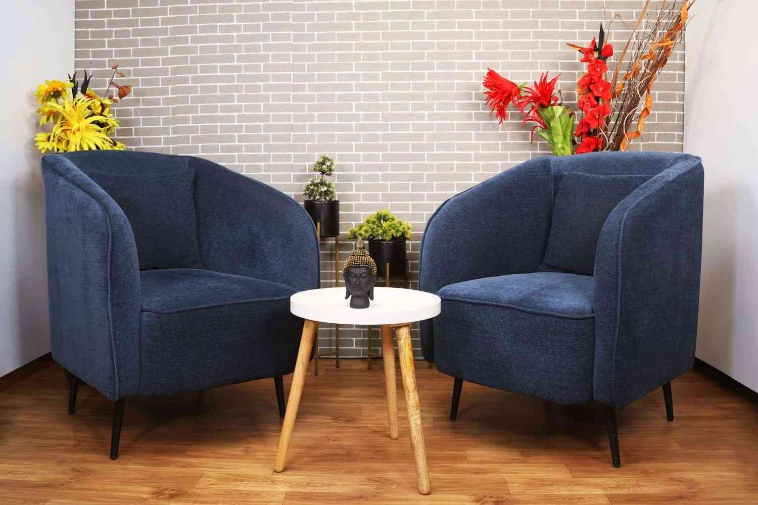 Two armchairs and a small table set up for a two-person podcast recording