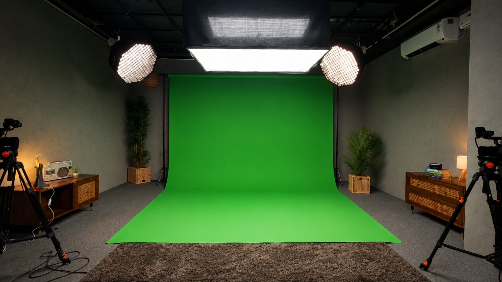 A green screen backdrop and floor lit by overhead studio lights